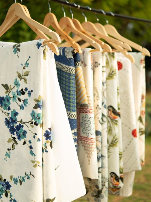 Bedsheets on hangers, sunlit